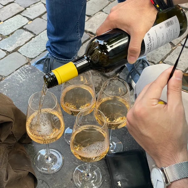 White wine being poured into four glasses